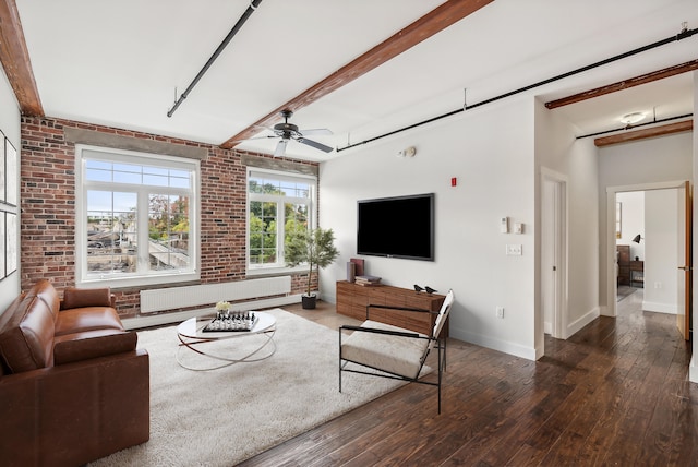 living room featuring dark wood-style floors, a ceiling fan, brick wall, and radiator heating unit