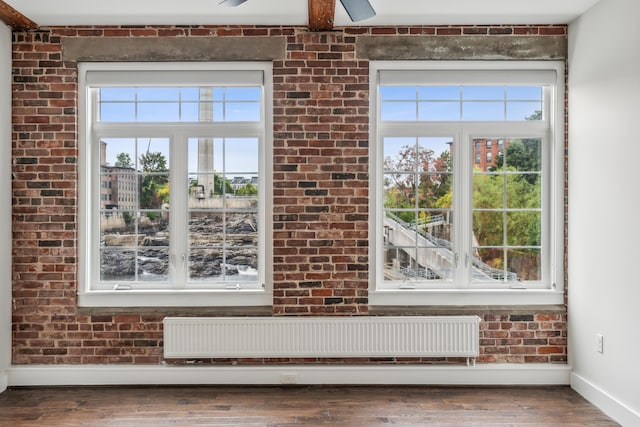 details featuring radiator heating unit, baseboards, and wood finished floors