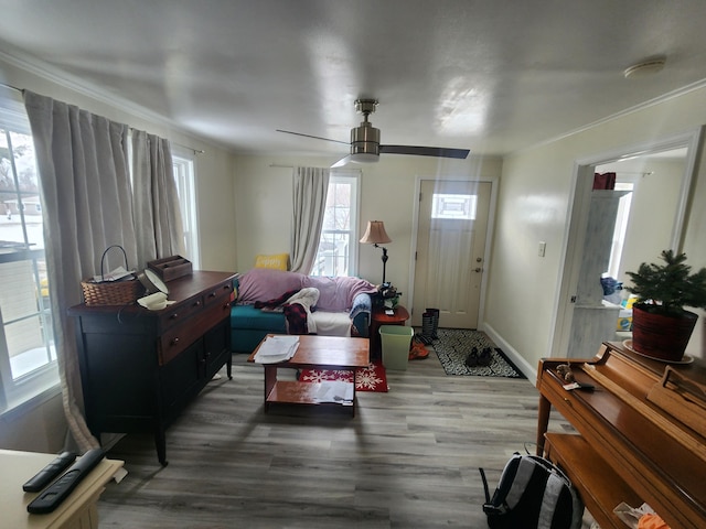 living room featuring baseboards, wood finished floors, a ceiling fan, and ornamental molding