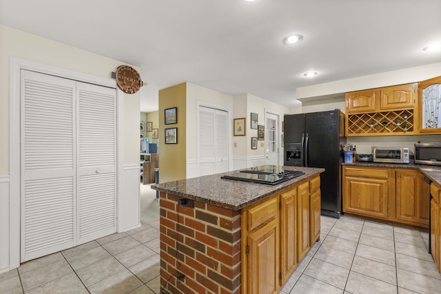 16 Rockaway Rd, Falmouth, ME 04105 - kitchen featuring a toaster, light tile patterned floors, a kitchen island, dark stone counters, and black appliances