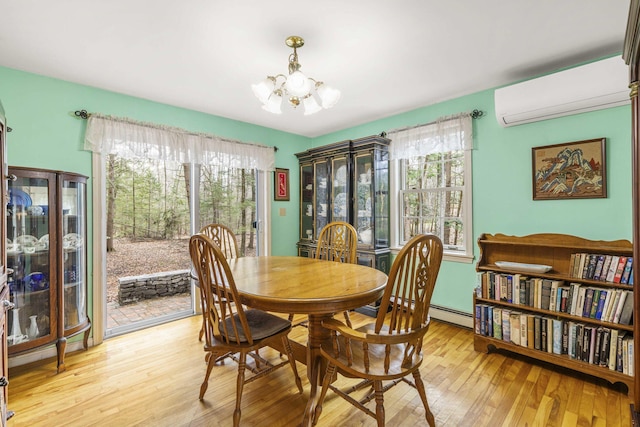16 Rockaway Rd, Falmouth, ME 04105 - dining space featuring wood-type flooring, a wall mounted AC, a chandelier, and plenty of natural light