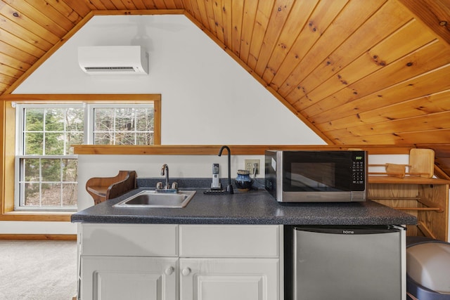 16 Rockaway Rd, Falmouth, ME 04105 - kitchen with refrigerator, white cabinetry, stainless steel microwave, a sink, and an AC wall unit