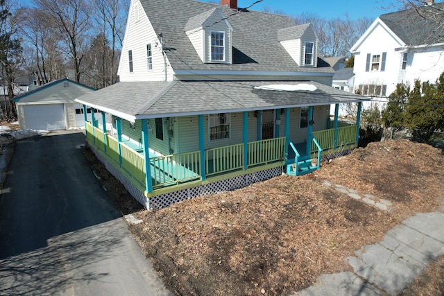 view of front facade featuring an outbuilding, a detached garage, a porch, a shingled roof, and a chimney