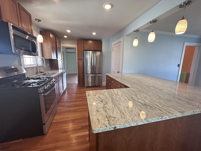 kitchen featuring ornamental molding, a sink, light stone counters, dark wood finished floors, and appliances with stainless steel finishes