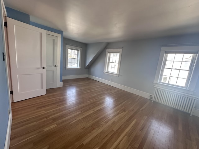 bonus room featuring baseboards, radiator, and hardwood / wood-style floors