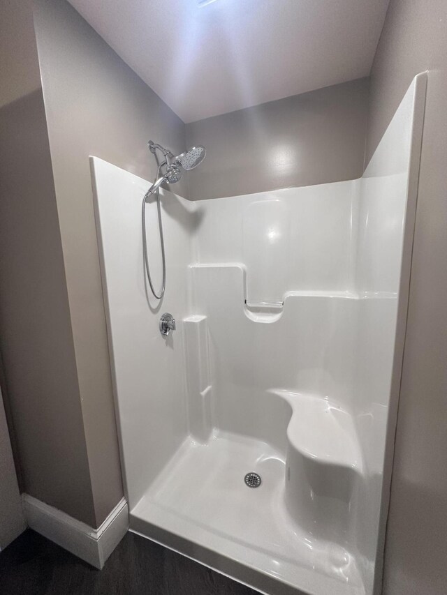 full bathroom with a shower and baseboards