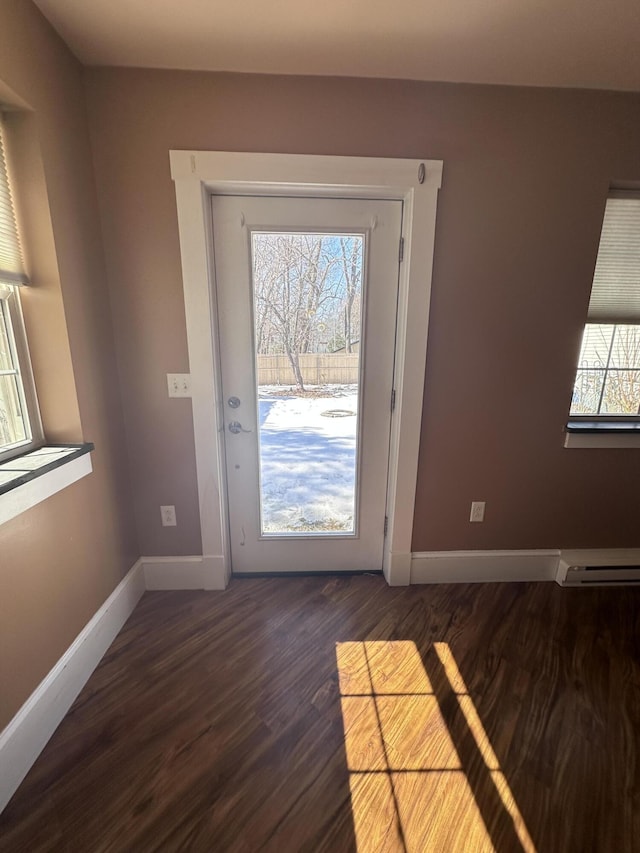 entryway with a baseboard heating unit, dark wood-type flooring, and baseboards