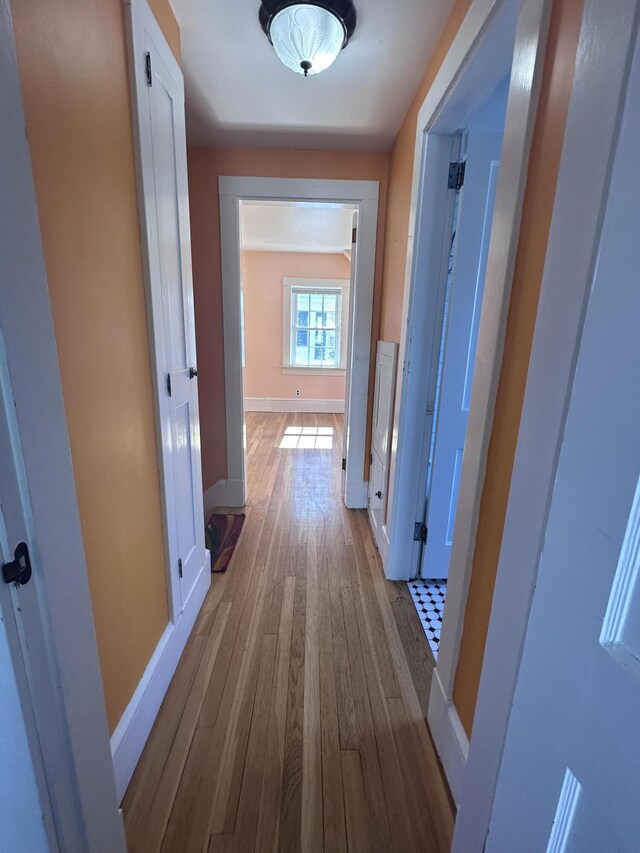 hallway featuring baseboards and light wood-style floors