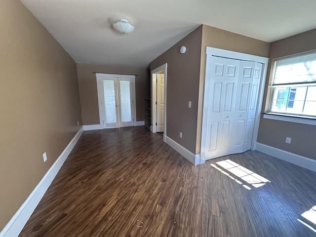 interior space featuring french doors, dark wood-type flooring, and baseboards