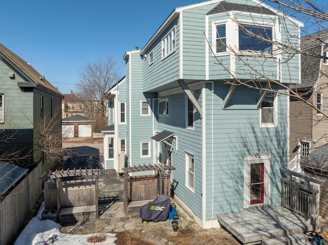 back of property featuring a wooden deck, a chimney, and fence