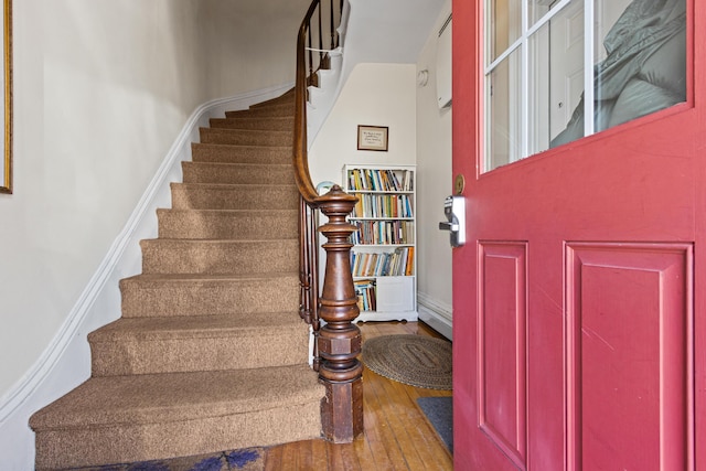 entryway with stairway, baseboards, and wood-type flooring