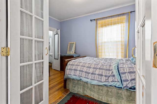 bedroom with wood finished floors and ornamental molding