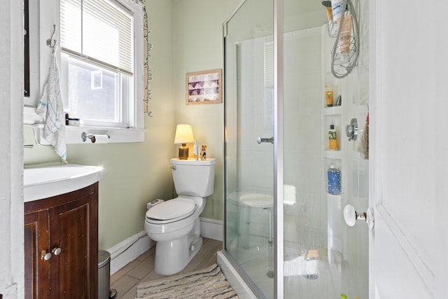 full bathroom featuring wood finish floors, baseboards, toilet, a stall shower, and vanity