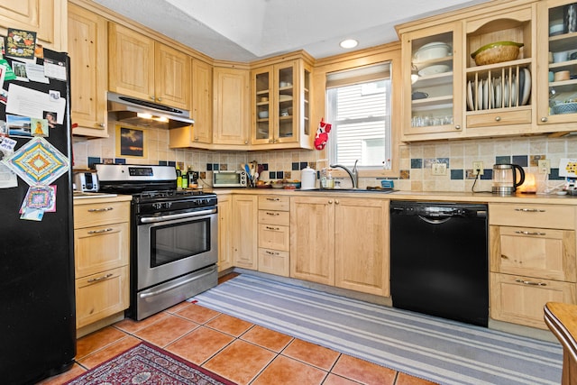 kitchen with black appliances, light brown cabinets, under cabinet range hood, a sink, and light tile patterned flooring