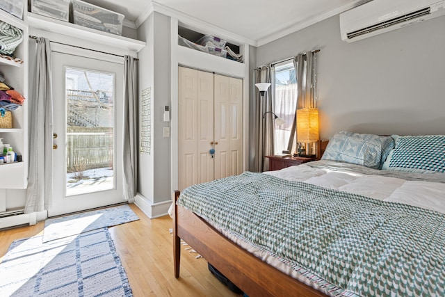 bedroom featuring light wood-style floors, an AC wall unit, ornamental molding, and access to outside