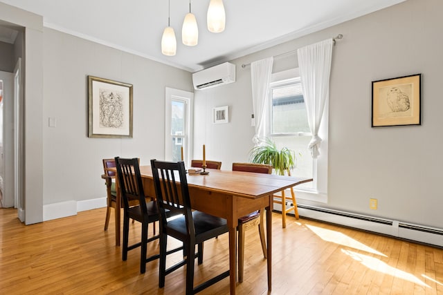 dining space with light wood finished floors, crown molding, a baseboard heating unit, baseboards, and an AC wall unit