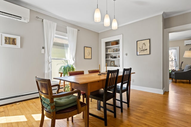 dining area with built in shelves, baseboards, light wood-style flooring, a wall mounted air conditioner, and crown molding