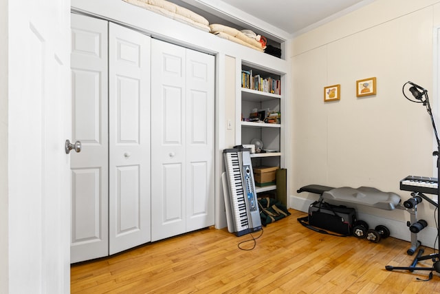 interior space with light wood-style floors, a closet, and ornamental molding