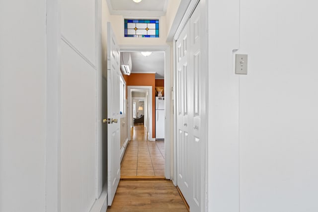 hallway with crown molding, light wood-style floors, and a wall mounted air conditioner