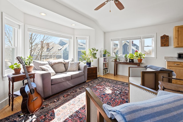 living area featuring a ceiling fan, wood finished floors, baseboards, lofted ceiling, and recessed lighting