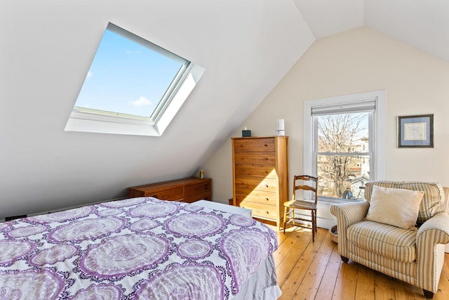 bedroom featuring lofted ceiling with skylight and light wood-style floors