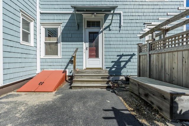 view of exterior entry featuring fence