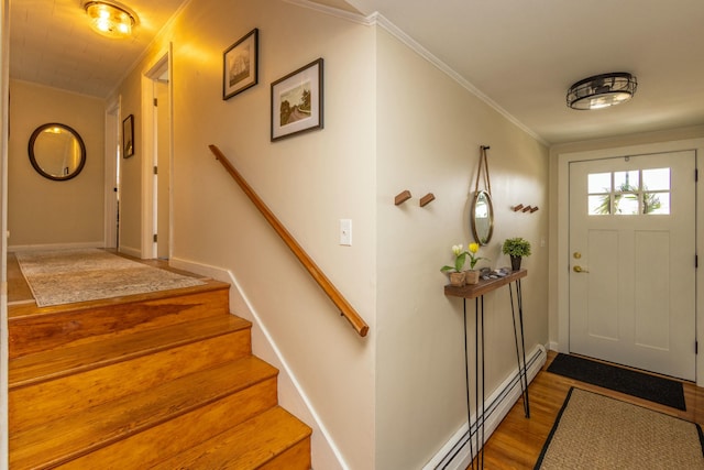 entrance foyer featuring wood finished floors, baseboards, stairs, crown molding, and baseboard heating