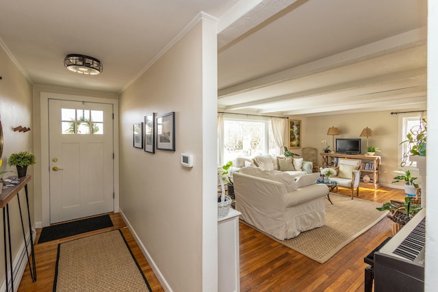 entryway featuring baseboards, wood finished floors, and ornamental molding