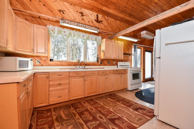 kitchen with a sink, white appliances, light brown cabinets, and light countertops