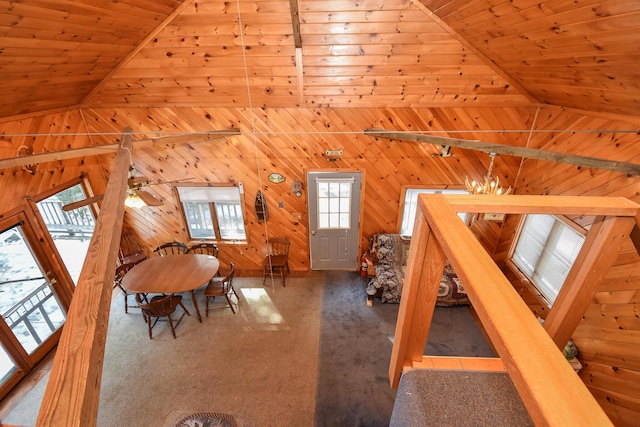 interior space featuring carpet, lofted ceiling, wood ceiling, and wood walls