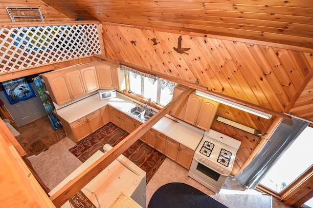 kitchen featuring a sink, white microwave, wood walls, and light brown cabinets