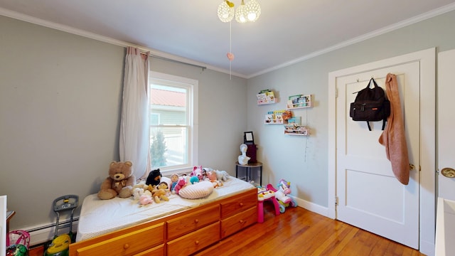 bedroom with light wood-type flooring, a notable chandelier, crown molding, baseboards, and baseboard heating