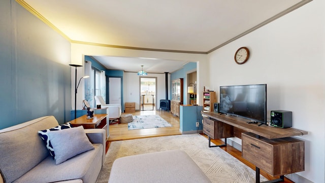 living area featuring crown molding, wood finished floors, and baseboards