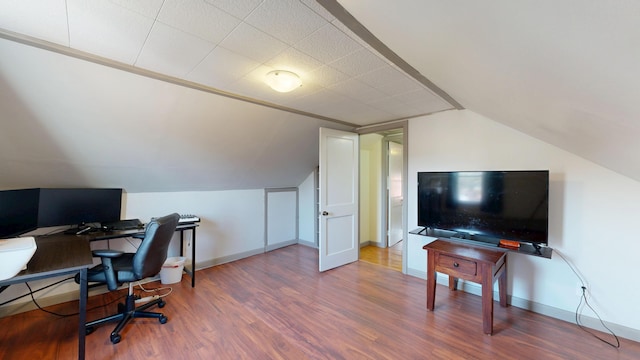 office area featuring lofted ceiling, baseboards, and wood finished floors