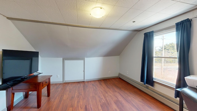 bonus room featuring a baseboard radiator, baseboards, wood finished floors, and vaulted ceiling