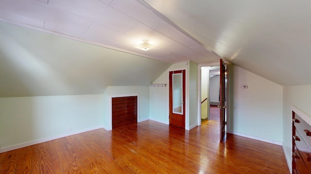 bonus room featuring vaulted ceiling, wood finished floors, and baseboards