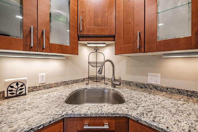 372 Skiway Rd Unit 204, Newry, ME 04261 - details with brown cabinets, a sink, and glass insert cabinets