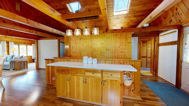 kitchen with beamed ceiling, a skylight, dark wood-style floors, and light countertops