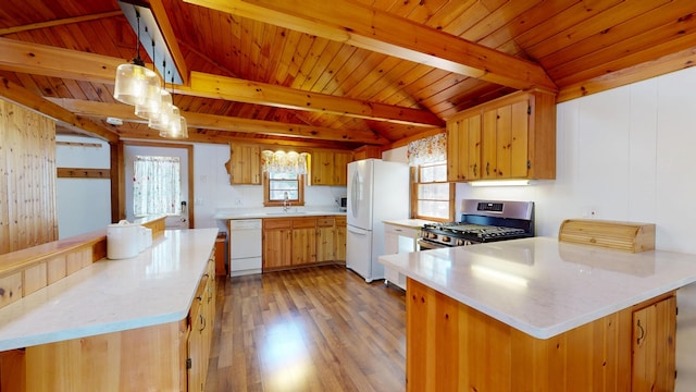kitchen with a sink, a peninsula, white appliances, and light countertops
