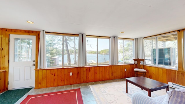 sunroom / solarium featuring a water view and a baseboard radiator