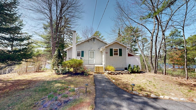 bungalow featuring fence and a chimney