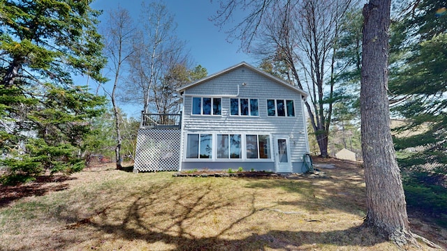 rear view of property with a lawn and a deck