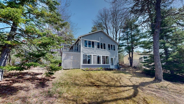rear view of property featuring a yard and a deck