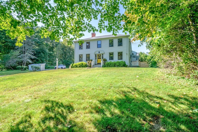 view of front of home with a chimney and a front yard