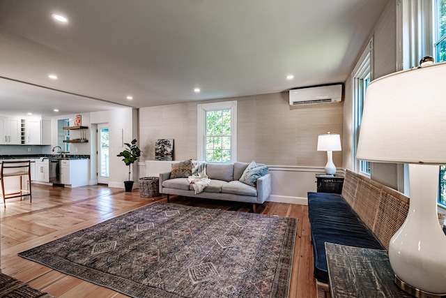living area with a wall unit AC, light wood-style flooring, recessed lighting, and baseboards