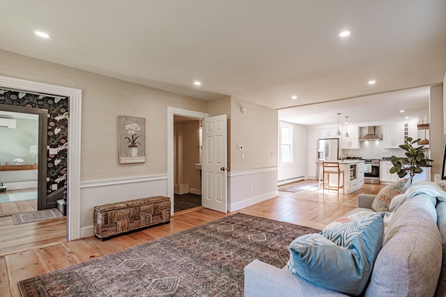 living area featuring an AC wall unit, recessed lighting, light wood-type flooring, and baseboards