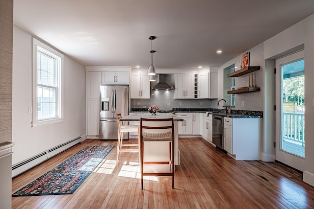 kitchen with a baseboard radiator, open shelves, stainless steel appliances, light wood-style floors, and wall chimney exhaust hood