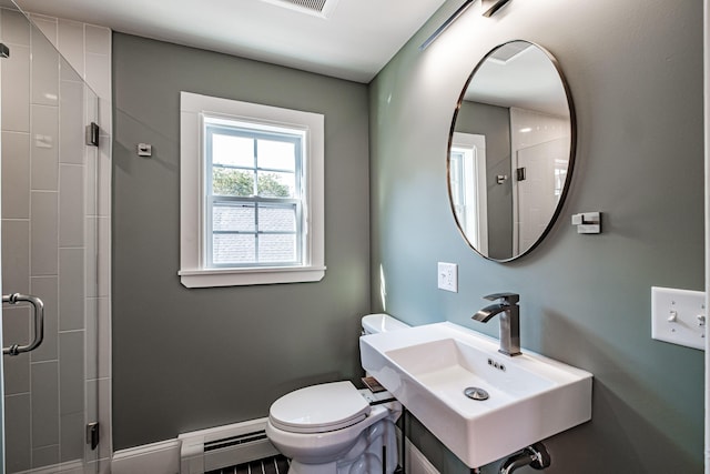 full bathroom with baseboards, a sink, a shower stall, toilet, and baseboard heating