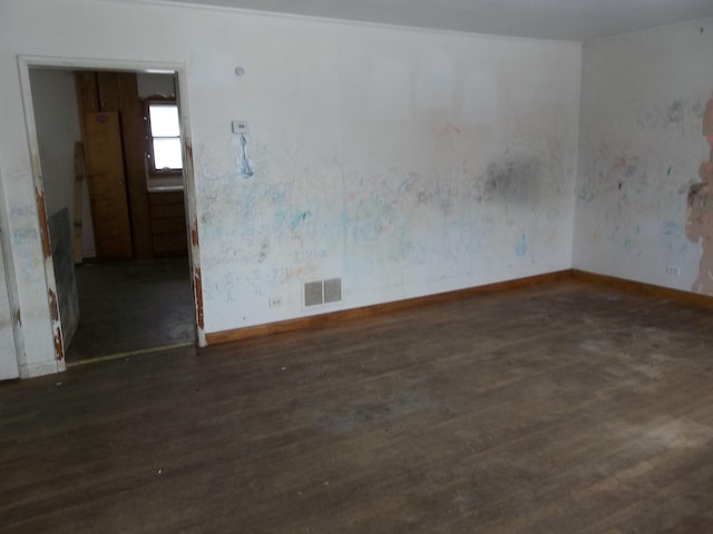 empty room with visible vents, baseboards, and wood finished floors