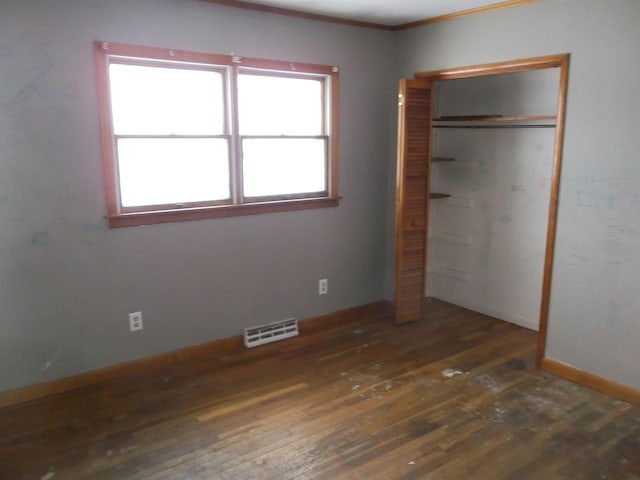 unfurnished bedroom with visible vents, baseboards, a closet, and hardwood / wood-style floors